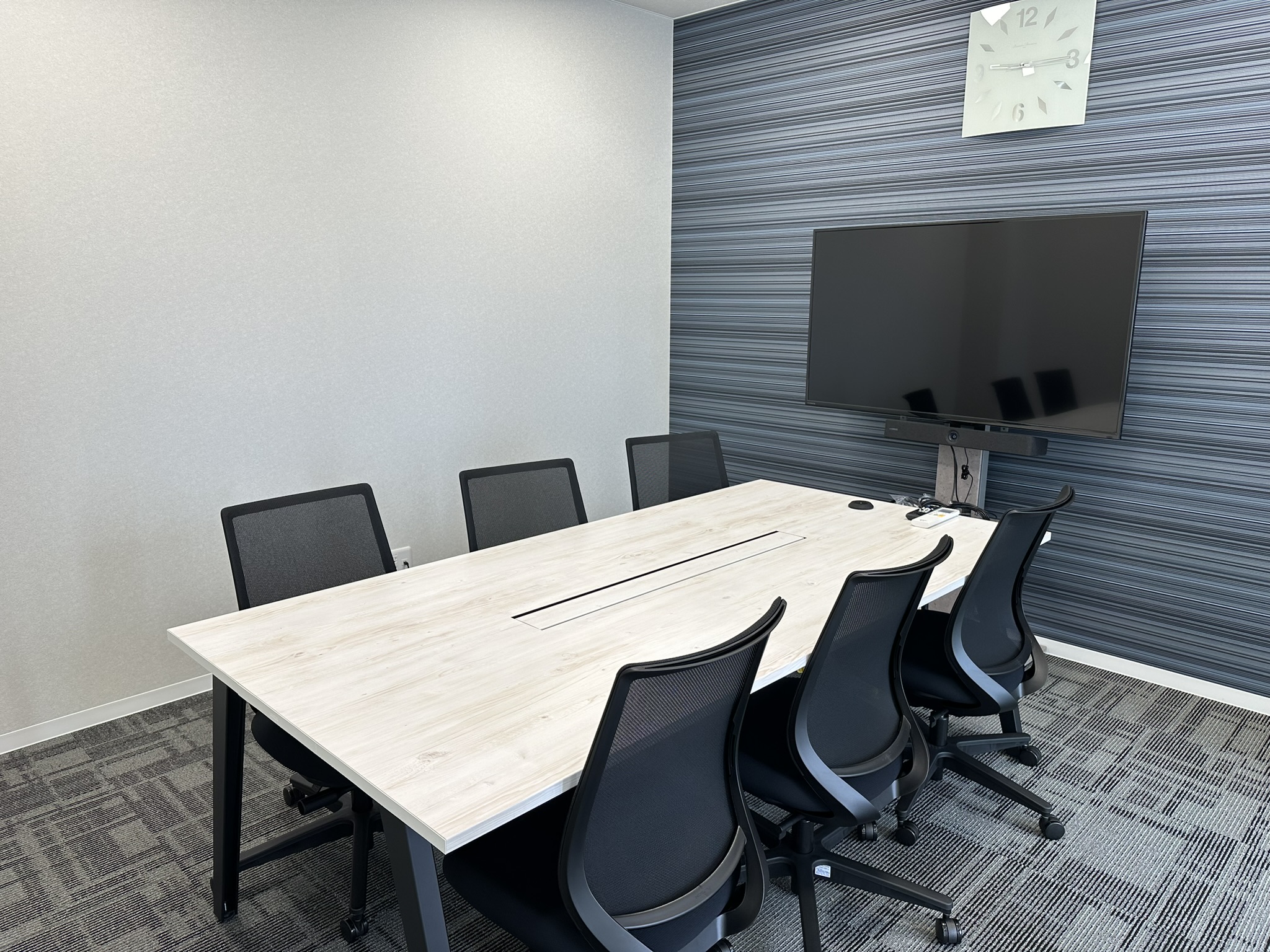 日本クレアス税理士法人 高崎本部の応接室。会議用テーブルとモニターを備えたミーティングスペース。